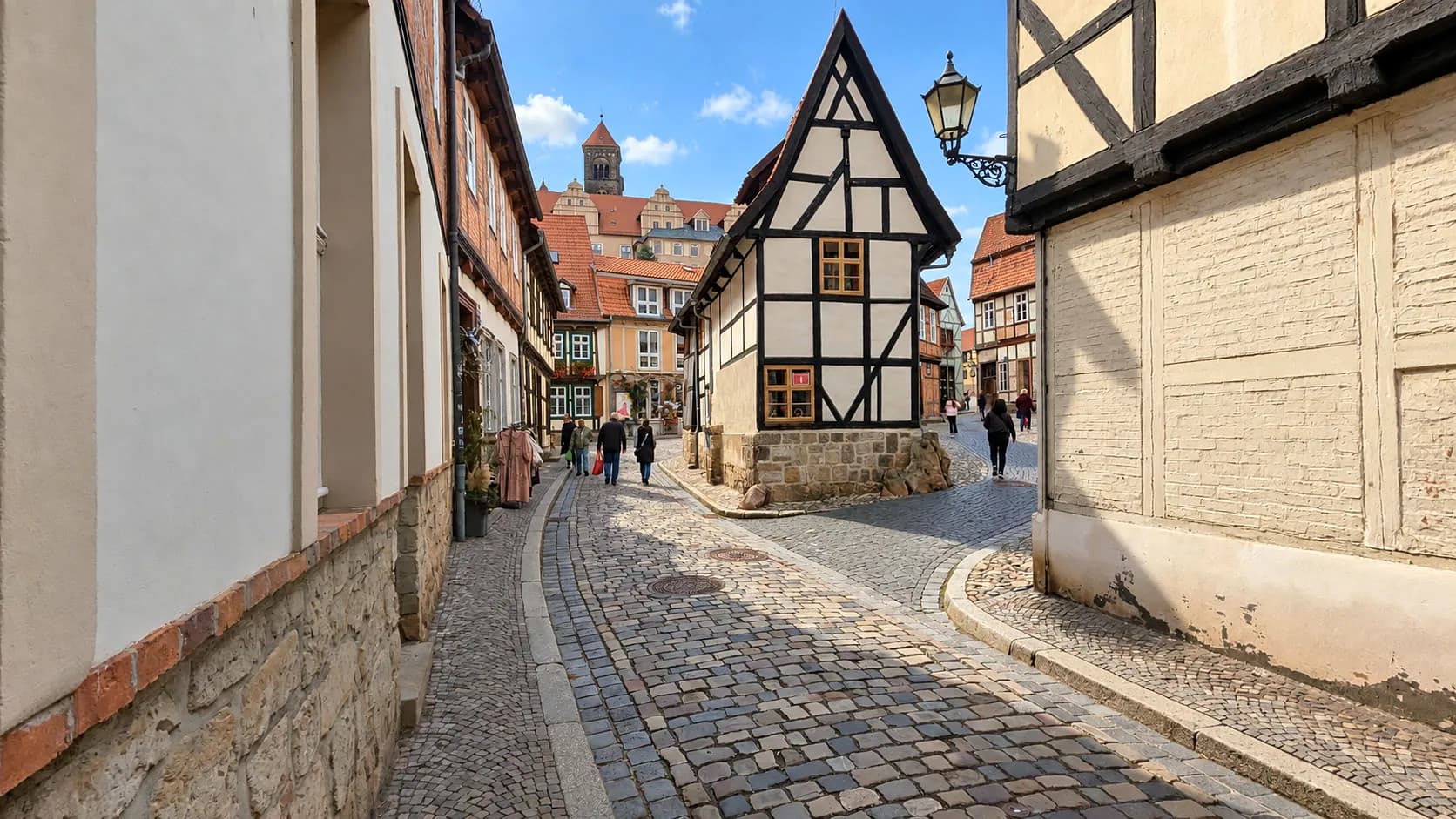 Weißes Fachwerkhaus in einer Kopfsteinpflastergasse der Quedlinburger Altstadt